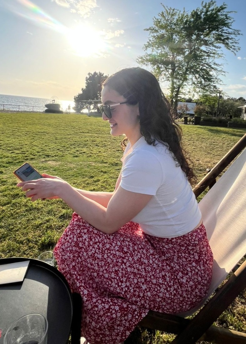 Person relaxing outdoors while working on their phone